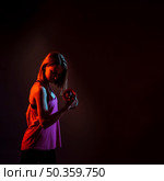 concentrated woman training bicep dark. Стоковое фото, агентство Ingram Publishing / Фотобанк Лори