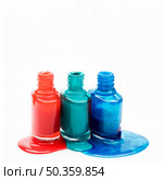 different shades nail polish spilled around three opened bottles. Стоковое фото, агентство Ingram Publishing / Фотобанк Лори