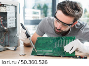 male technician repairing computer circuit board. Стоковое фото, агентство Ingram Publishing / Фотобанк Лори