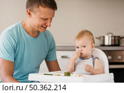father cute baby highchair eating. Стоковое фото, агентство Ingram Publishing / Фотобанк Лори