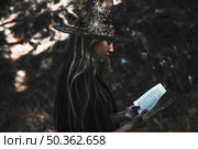 lady witch costume reading book. Стоковое фото, агентство Ingram Publishing / Фотобанк Лори