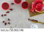red asian cup teapot with herbs textured grey background. Стоковое фото, агентство Ingram Publishing / Фотобанк Лори