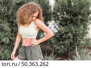 slim young woman looking waist injury. Стоковое фото, агентство Ingram Publishing / Фотобанк Лори
