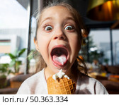 surprised girl eating ice cream close up. Стоковое фото, агентство Ingram Publishing / Фотобанк Лори