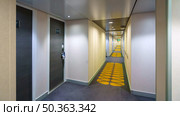 Tokyo, Japan - Oct 2 2024, panoramic view of the long corridor between the doors of living cabins on one of decks of the MSC Bellissima cruise ship, without people, Tokyo, Japan. Редакционное фото, фотограф Сергей Богомяко / Фотобанк Лори