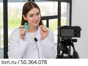 blogger recording video with dental floss. Стоковое фото, агентство Ingram Publishing / Фотобанк Лори