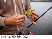 close up man tying lure fishing hook. Стоковое фото, агентство Ingram Publishing / Фотобанк Лори