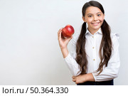diligent hispanic schoolgirl eating apple. Стоковое фото, агентство Ingram Publishing / Фотобанк Лори