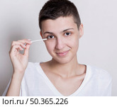woman holding ear cotton bud. Стоковое фото, агентство Ingram Publishing / Фотобанк Лори