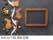 flat lay bunny shaped cookies chocolate eater eggs with blackboard. Стоковое фото, агентство Ingram Publishing / Фотобанк Лори