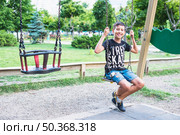 portrait happy boy sitting swing. Стоковое фото, агентство Ingram Publishing / Фотобанк Лори