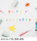 prop party horn party hat around happy birthday candles against white background. Стоковое фото, агентство Ingram Publishing / Фотобанк Лори