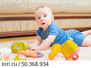 cute baby boy laying carpet with toys. Стоковое фото, агентство Ingram Publishing / Фотобанк Лори
