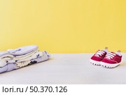newborn concept with baby shoes pile clothes. Стоковое фото, агентство Ingram Publishing / Фотобанк Лори