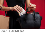 woman putting her money her purse. Стоковое фото, агентство Ingram Publishing / Фотобанк Лори