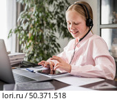 little girl participating online class while using tablet. Стоковое фото, агентство Ingram Publishing / Фотобанк Лори
