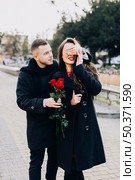man with roses surprising young girl. Стоковое фото, агентство Ingram Publishing / Фотобанк Лори