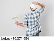 back view worker holding paint roller. Стоковое фото, агентство Ingram Publishing / Фотобанк Лори