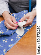 close up person s hand stitching floral fabric with needles desk. Стоковое фото, агентство Ingram Publishing / Фотобанк Лори