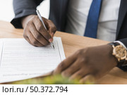 crop ethnic businessman signing papers. Стоковое фото, агентство Ingram Publishing / Фотобанк Лори