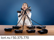 Businesswoman answering a lot of calls at the same time. Стоковое фото, агентство Ingram Publishing / Фотобанк Лори