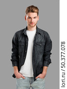 Good looking young man smiling with hands in the pockets, isolated over a gray background. Стоковое фото, агентство Ingram Publishing / Фотобанк Лори