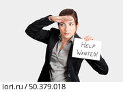 Business woman search for help holding a cardboard with the text message "Help Wanted" Стоковое фото, агентство Ingram Publishing / Фотобанк Лори