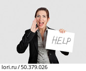 Business woman calling for help holding a cardboard with the text message "Help" Стоковое фото, агентство Ingram Publishing / Фотобанк Лори