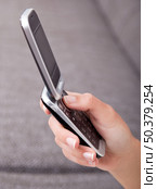 Female hand holding a cellphone and sending a sms. Стоковое фото, агентство Ingram Publishing / Фотобанк Лори
