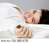 Beautiful young women lying on the bed and smilling. Стоковое фото, агентство Ingram Publishing / Фотобанк Лори