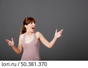 Happy young woman dancing and singing while listen music. Стоковое фото, агентство Ingram Publishing / Фотобанк Лори