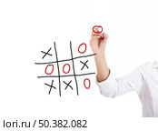 Young businesswoman playing the game noughts and crosses. Стоковое фото, агентство Ingram Publishing / Фотобанк Лори