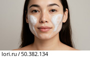 Portrait of beautiful asian woman washing face with cleansing foam. Concept for daily skincare routine and beauty cosmetic product. Стоковое AI-изображение, AI-художник Павел Муравьев / Фотобанк Лори