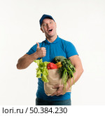 delivery man giving thumbs up holding grocery bag. Стоковое фото, агентство Ingram Publishing / Фотобанк Лори