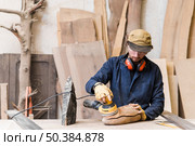 man sanding wood with orbital sander workshop. Стоковое фото, агентство Ingram Publishing / Фотобанк Лори