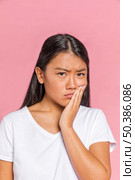 black hair woman frowning looking camera. Стоковое фото, агентство Ingram Publishing / Фотобанк Лори