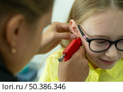 Прокалывание ушей девочке в салоне красоты. Стоковое фото, фотограф Анатолий Зеленков / Фотобанк Лори