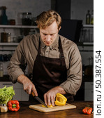 mid shot chef slicing bell peppers. Стоковое фото, агентство Ingram Publishing / Фотобанк Лори