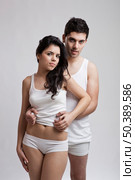 Beautiful and attractive young couple in underwear standing over a white background. Стоковое фото, агентство Ingram Publishing / Фотобанк Лори