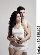 Beautiful and attractive young couple in underwear standing over a white background. Стоковое фото, агентство Ingram Publishing / Фотобанк Лори