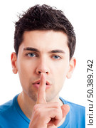 Portrait of a young man asking for silence, isolated on white background. Стоковое фото, агентство Ingram Publishing / Фотобанк Лори