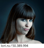 Beautiful young woman over a grey backround with a funny expression. Стоковое фото, агентство Ingram Publishing / Фотобанк Лори