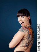 Portrait of a beautiful young woman with tattoos and winking. Стоковое фото, агентство Ingram Publishing / Фотобанк Лори