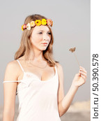 Beautiful young woman in a meadow wearing a crown of flowers. Стоковое фото, агентство Ingram Publishing / Фотобанк Лори