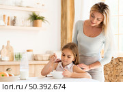 mother watching her daughter eat breakfast. Стоковое фото, агентство Ingram Publishing / Фотобанк Лори