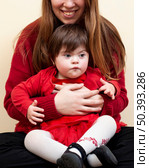 smiley woman holding child with down syndrome. Стоковое фото, агентство Ingram Publishing / Фотобанк Лори