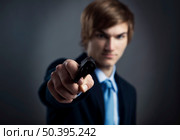 Stressed businessman holding and pointing a gun to the camera. Стоковое фото, агентство Ingram Publishing / Фотобанк Лори