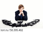 Businessman sitting with a bunch telephones on his front. Стоковое фото, агентство Ingram Publishing / Фотобанк Лори