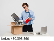 Young man in the office packing up after being fired. Стоковое фото, агентство Ingram Publishing / Фотобанк Лори