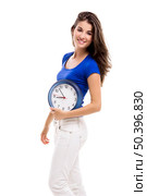 Causal young woman holding a clock, isolated over a white background. Стоковое фото, агентство Ingram Publishing / Фотобанк Лори